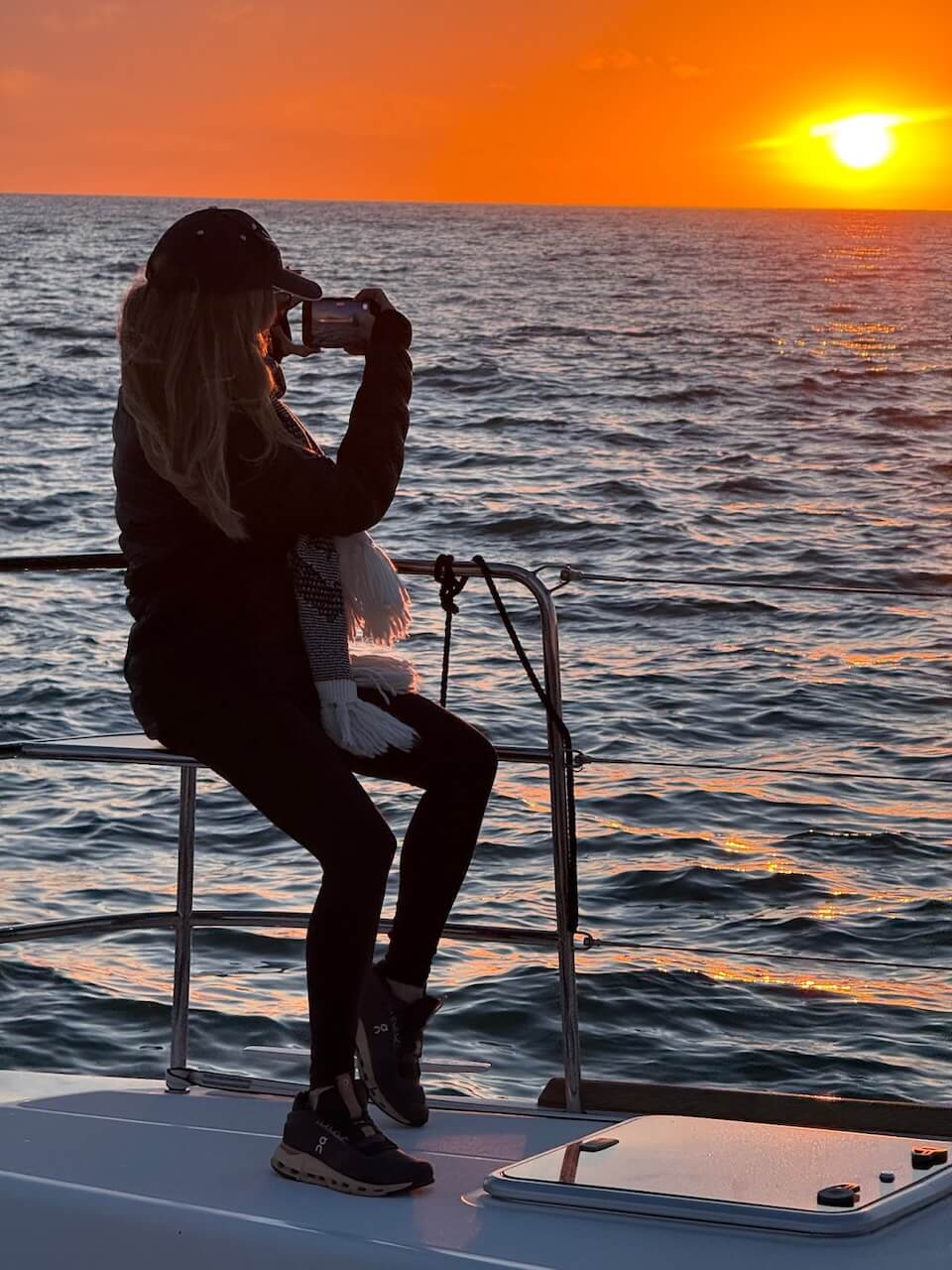 Woman taking a picture of the sunset during a sunset cruise in Marina del Rey