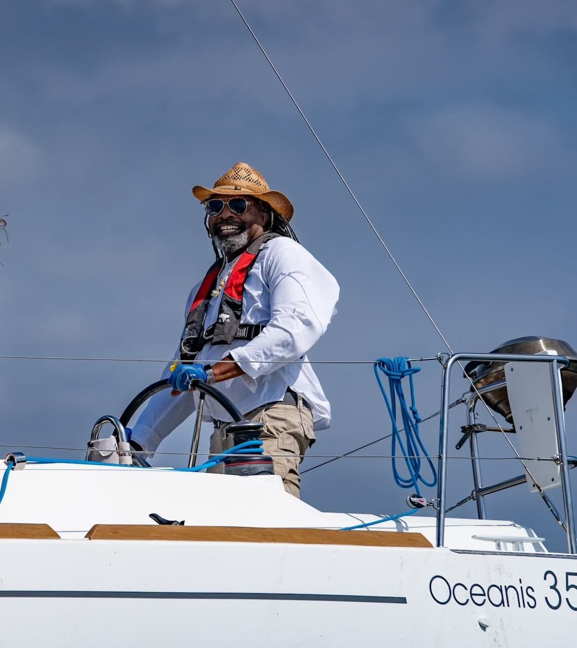 Marina del Rey boat charter captain steering a 35 foot Oceanis sailboat.