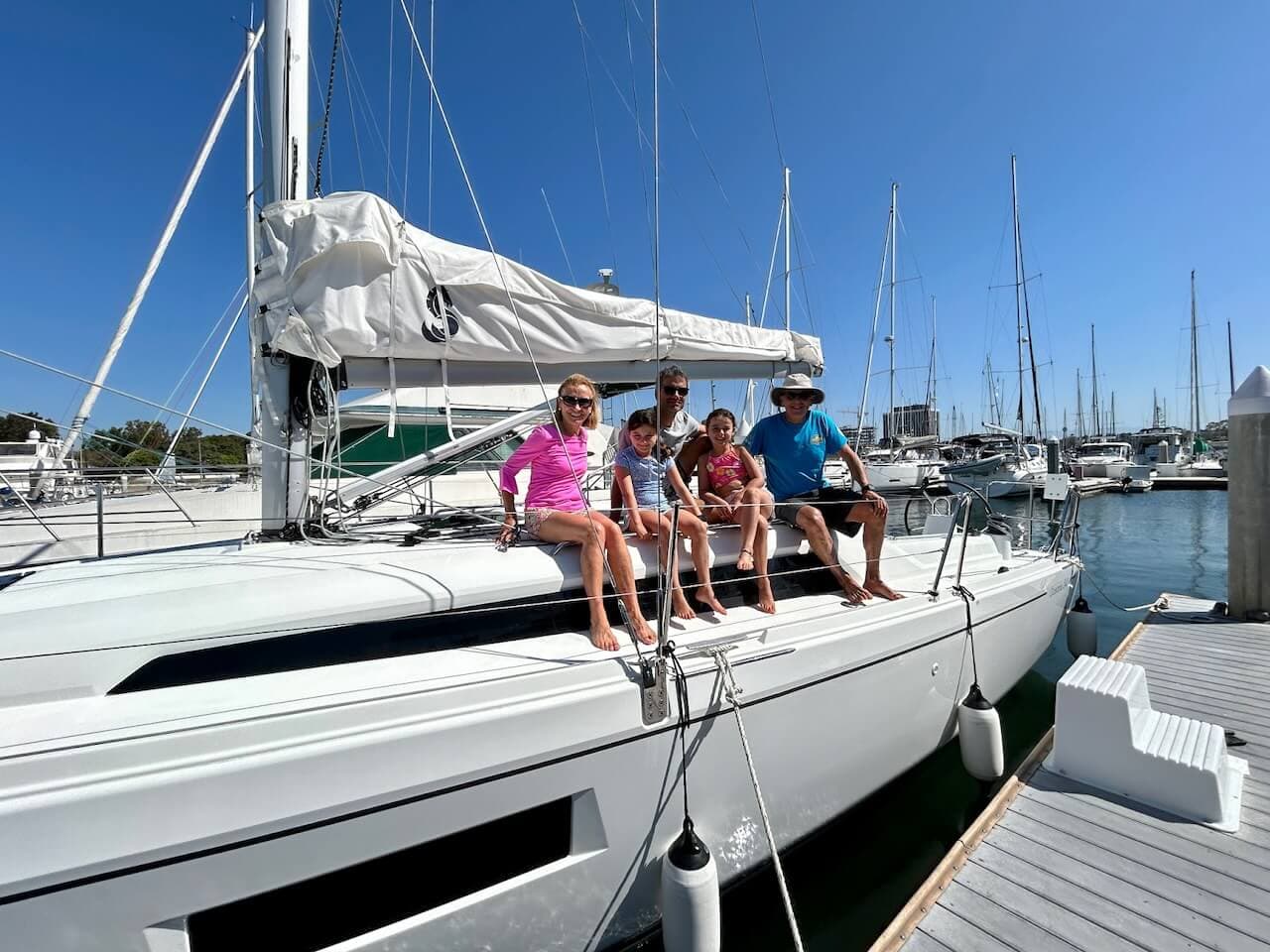 Family sitting on the side of a sailboat after they rented a sailboat in Marina del Rey