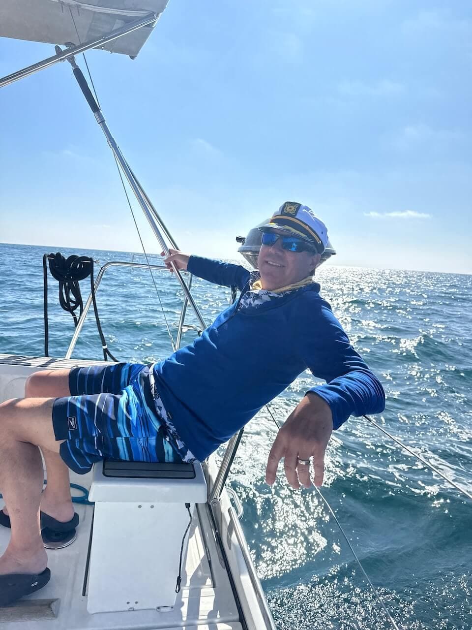 Man relaxing at the helm of a boat during a private boat charter