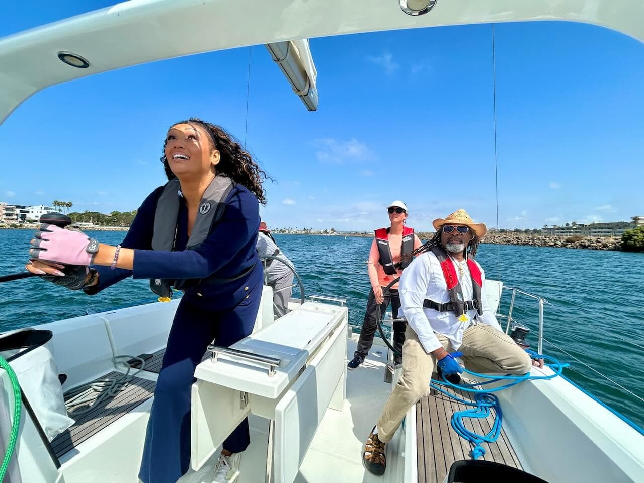 woman raising the sails on a sailboat during a boat charter in Marina del Rey