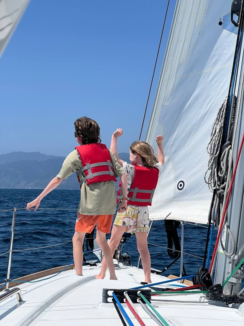 2 Kids standing on the bow of a sailboat as they charter a boat in Marina del Rey