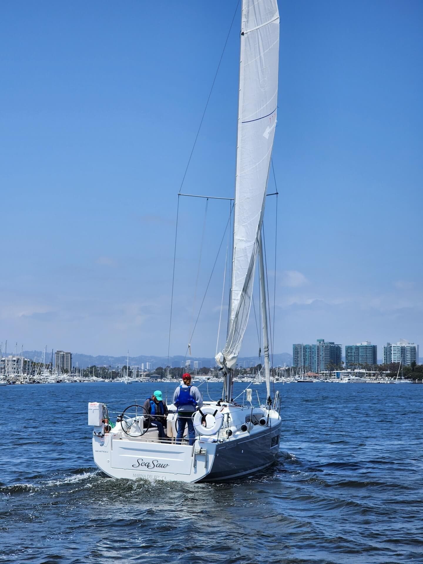 Sailing in Marina del Rey, boats on the water with cityscape in the background.