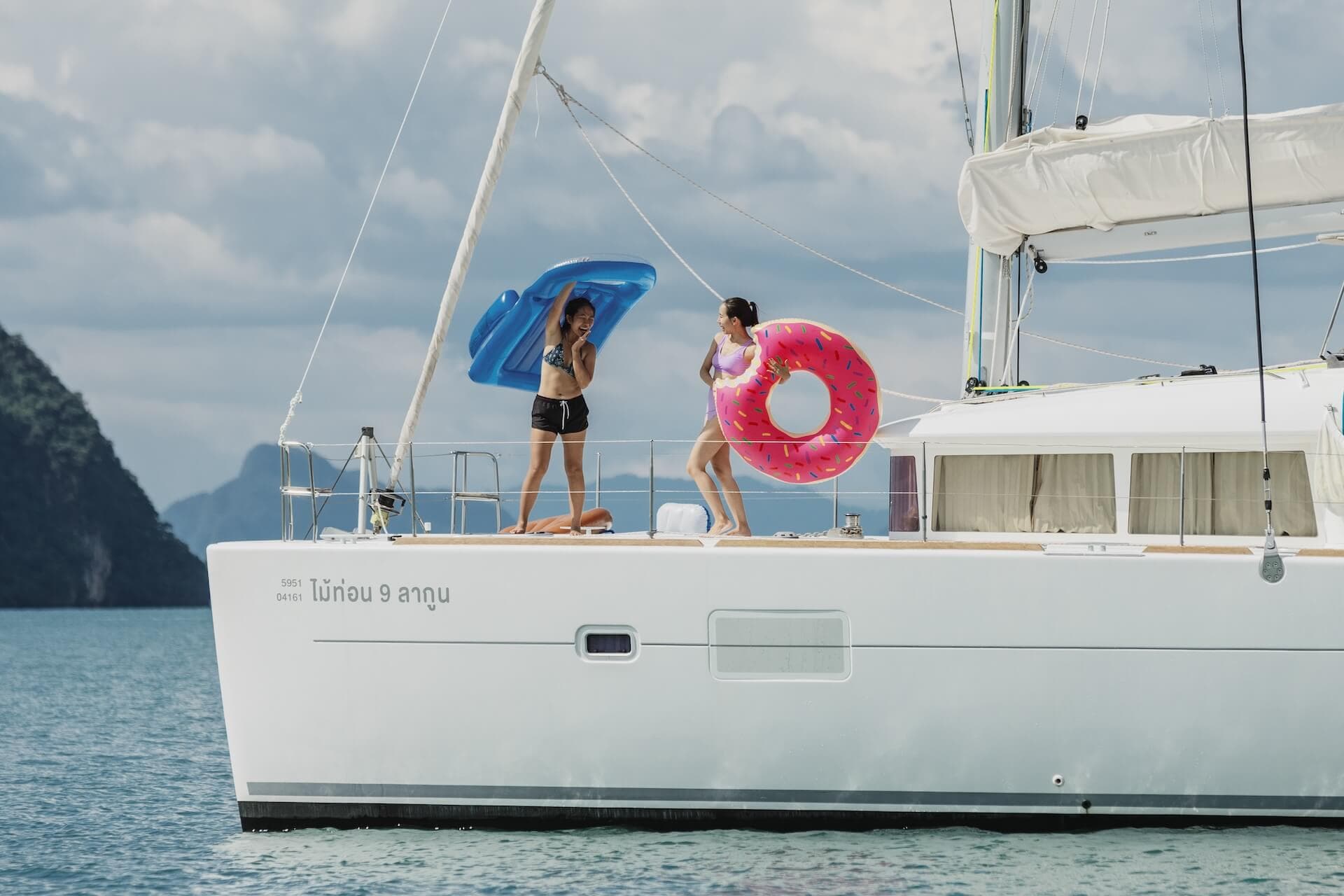 Family relaxing on the trampoline of a Beneteau catamaran